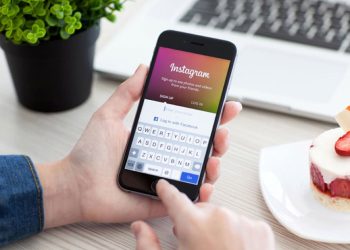 a man holding a phone looking at his instagram account
